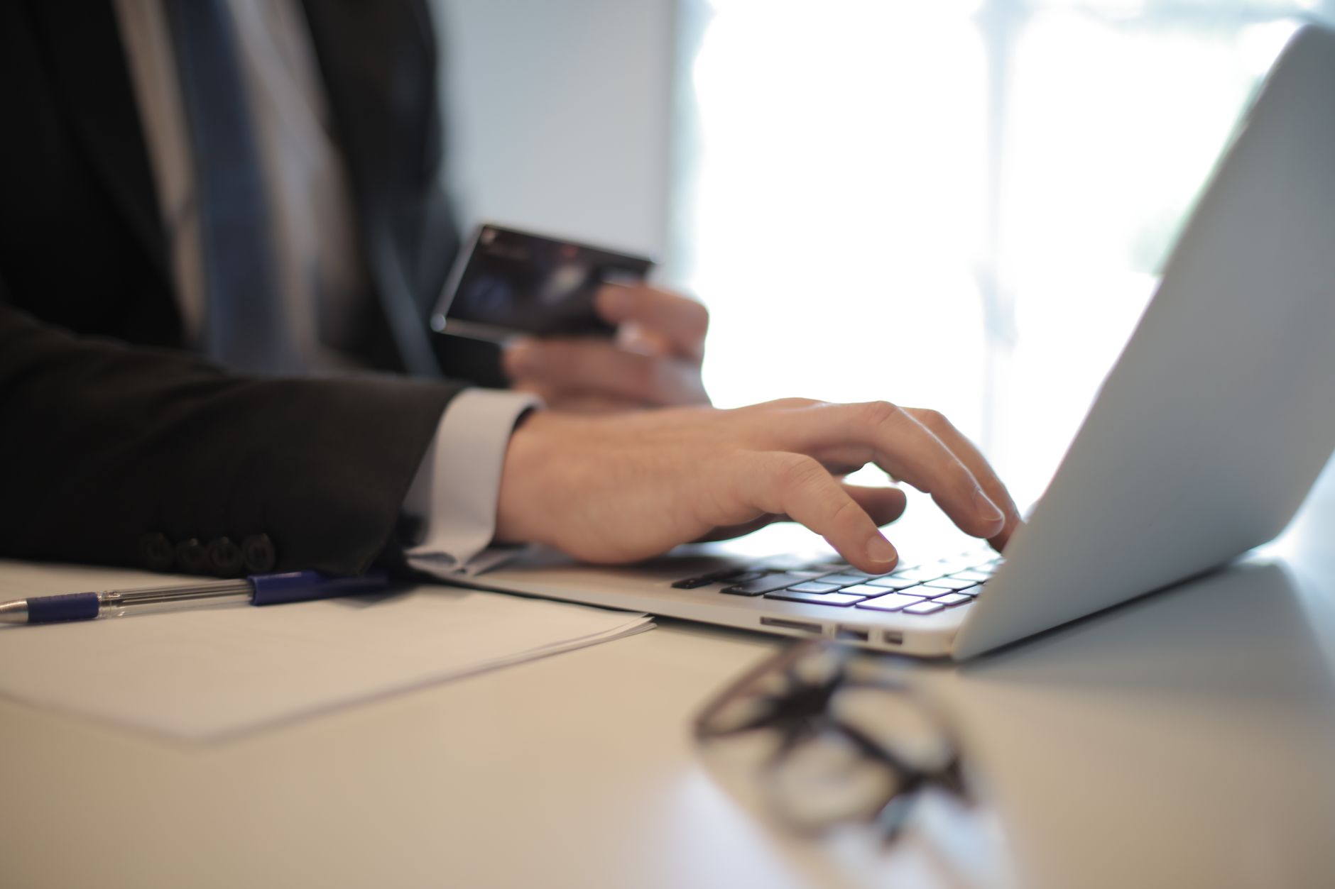 Ecommerce professional reviewing product information on a laptop while preparing customer assistance.