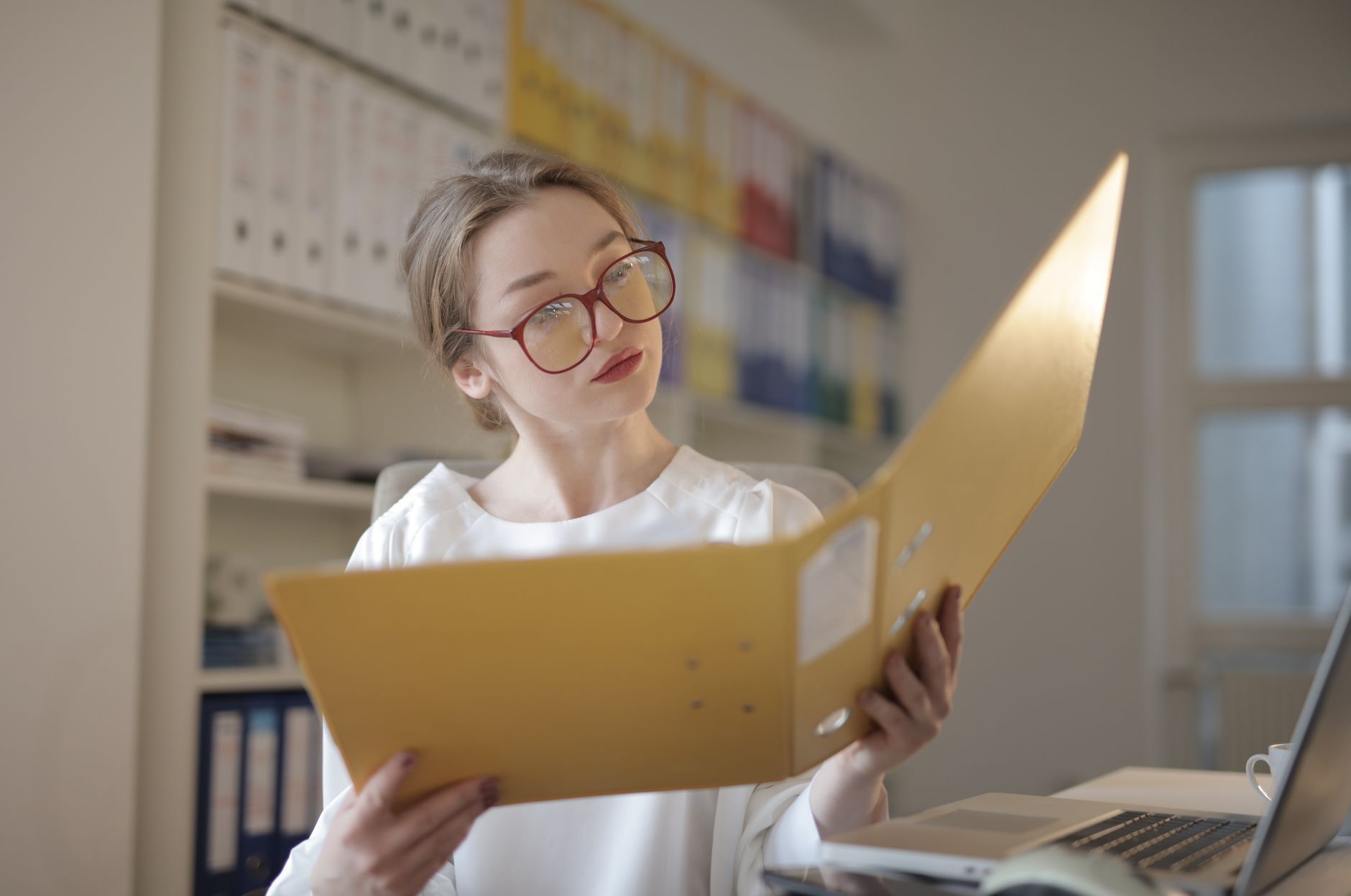 Writer reviewing a document on a laptop while editing online content for clarity and accuracy.