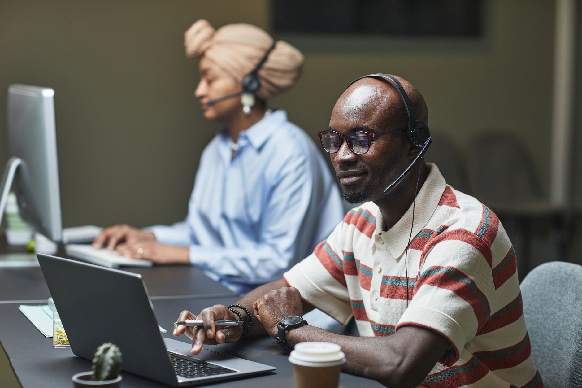 Customer support professional responding to online inquiries at a computer in a modern office.
